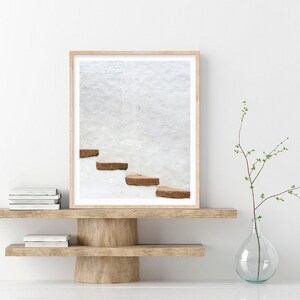Puede incluir: Una fotograf&iacute;a enmarcada de una pared blanca con un conjunto de escalones de ladrillo marr&oacute;n que conducen hacia arriba.