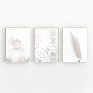 May include: Set of three minimalist art prints featuring abstract floral and feather designs in shades of white and gray.