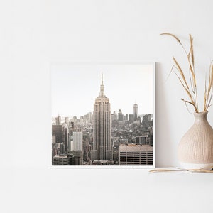 May include: A black and white photograph of the New York City skyline with the Empire State Building in the center.