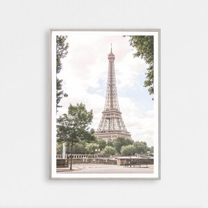 May include: A framed photograph of the Eiffel Tower in Paris, France. The tower is visible through a frame of trees. The photo is taken from a street level perspective.