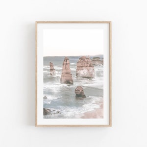 May include: A photograph of the Twelve Apostles, a collection of limestone stacks off the coast of Port Campbell National Park in Victoria, Australia. The stacks are surrounded by a misty, blue ocean.