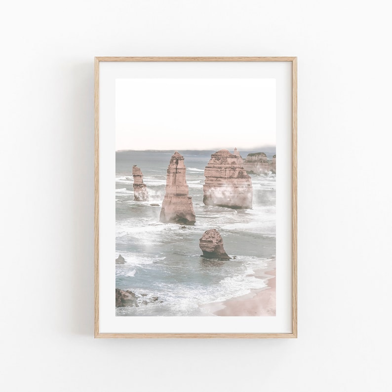 May include: A photograph of the Twelve Apostles, a collection of limestone stacks off the coast of Port Campbell National Park in Victoria, Australia. The stacks are surrounded by a misty, blue ocean.