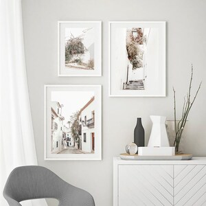 May include: Three framed prints of white buildings with a white background. The prints are hung on a white wall. The prints are all different sizes and shapes. The prints are all in a white frame.