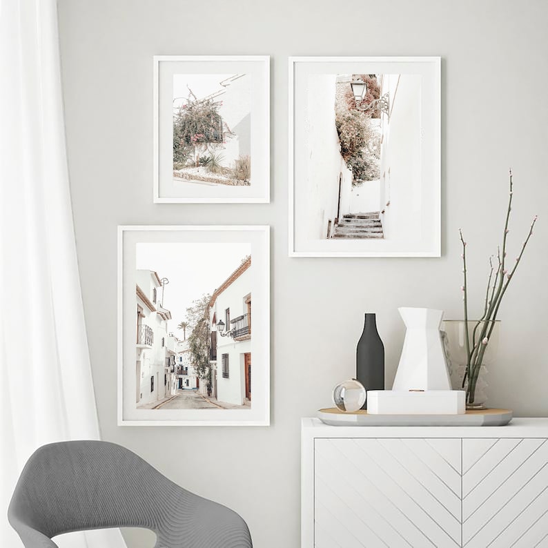 May include: Three framed prints of white buildings with a white background. The prints are hung on a white wall. The prints are all different sizes and shapes. The prints are all in a white frame.