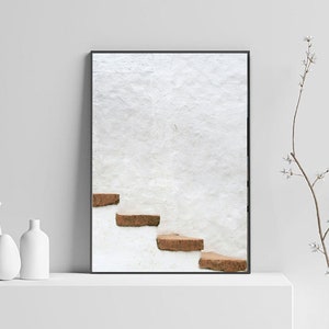 Puede incluir: Una fotograf&iacute;a enmarcada de una pared blanca con un conjunto de escalones marrones que conducen a la cima. Los escalones est&aacute;n hechos de piedra toscamente labrada y est&aacute;n colocados contra una pared blanca.
