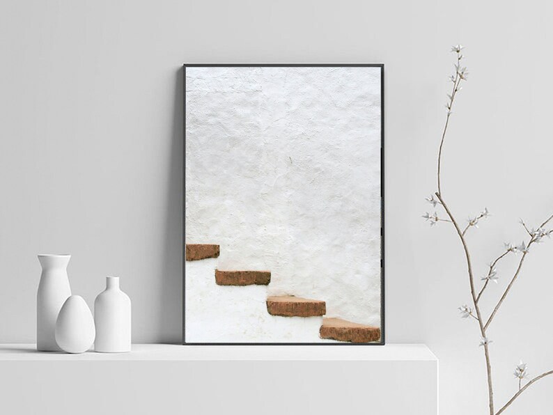Puede incluir: Una fotograf&iacute;a enmarcada de una pared blanca con un conjunto de escalones marrones que conducen a la cima. Los escalones est&aacute;n hechos de piedra toscamente labrada y est&aacute;n colocados contra una pared blanca.