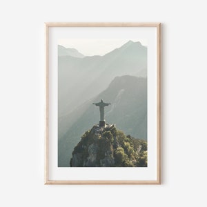 May include: A photograph of the Christ the Redeemer statue in Rio de Janeiro, Brazil. The statue is perched atop a mountain with a misty background.