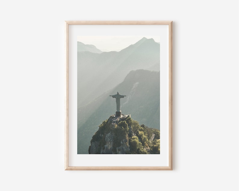 May include: A photograph of the Christ the Redeemer statue in Rio de Janeiro, Brazil. The statue is perched atop a mountain with a misty background.