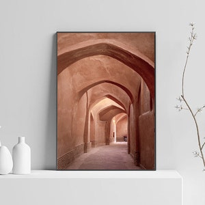 May include: A photograph of a narrow, arched hallway with terracotta walls. The hallway is lit by natural light, creating a warm and inviting atmosphere.