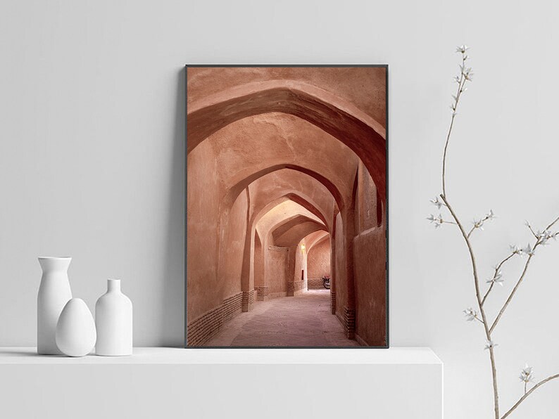 May include: A photograph of a narrow, arched hallway with terracotta walls. The hallway is lit by natural light, creating a warm and inviting atmosphere.