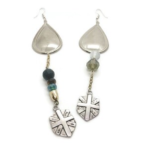 May include: A pair of silver teardrop earrings with a silver shield charm and beads in shades of green and brown.