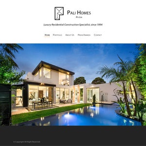 May include: A modern, white house with a swimming pool and landscaping. The house has large windows and a flat roof. The pool is surrounded by a deck and a grassy area. The house is lit up at night, and the sky is dark blue.