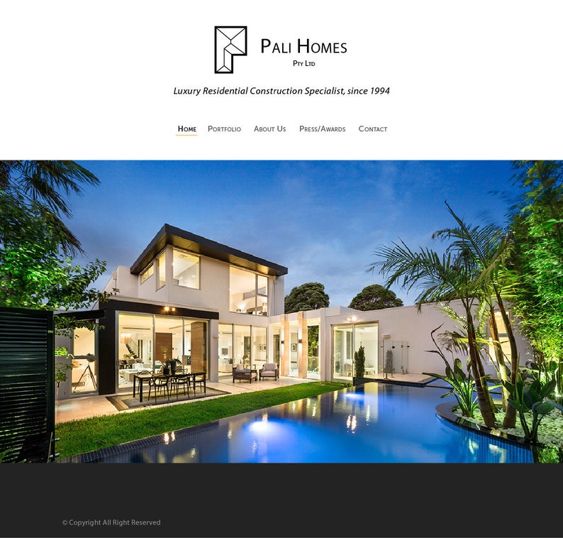 May include: A modern, white house with a swimming pool and landscaping. The house has large windows and a flat roof. The pool is surrounded by a deck and a grassy area. The house is lit up at night, and the sky is dark blue.