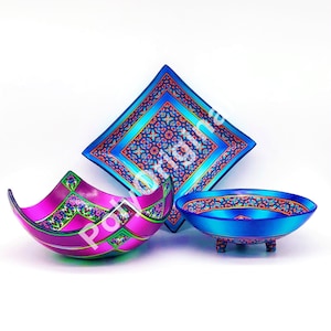 Puede incluir: Tres cuencos decorativos con intrincados patrones geométricos en tonos azules, rosas y verdes. Los cuencos están hechos de cerámica y tienen un acabado brillante.