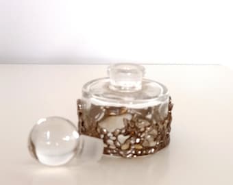 Pequeño frasco de perfume recargable de vidrio vintage con guirnalda en tono plateado.