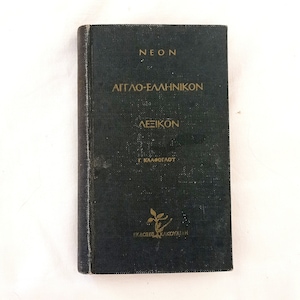 Könnte beinhalten: Ein schwarzes Hardcover-Buch mit goldenen Lettern auf dem Rücken und dem vorderen Umschlag. Der Titel lautet "NEON  ATTΛO-EΛΛHNIKON  ΛEIKON  Γ. ΚΑΛΛΟΓΛΩΤΤ  EKΔΟΣΕΙΣ ΚΑΚΟΥΛΛΙΑΗ".