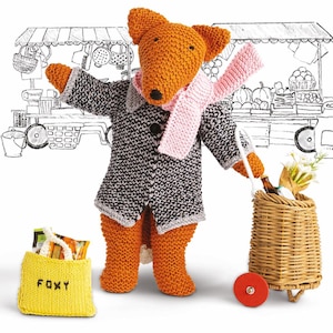 Puede incluir: Un zorro de punto que lleva un abrigo gris y blanco y una bufanda rosa, sosteniendo una cesta de la compra con un ramo de flores y una botella de vino. El zorro está de pie frente a un dibujo en blanco y negro de un puesto de mercado.