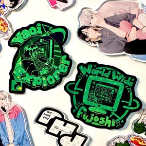 Puede incluir: Una colección de pegatinas de estilo anime sobre un fondo blanco. Las pegatinas presentan ilustraciones de personajes de anime y texto, incluyendo "Yaoi Explorer" y "World Wide Fujoshi". Las pegatinas tienen un esquema de color verde y negro.