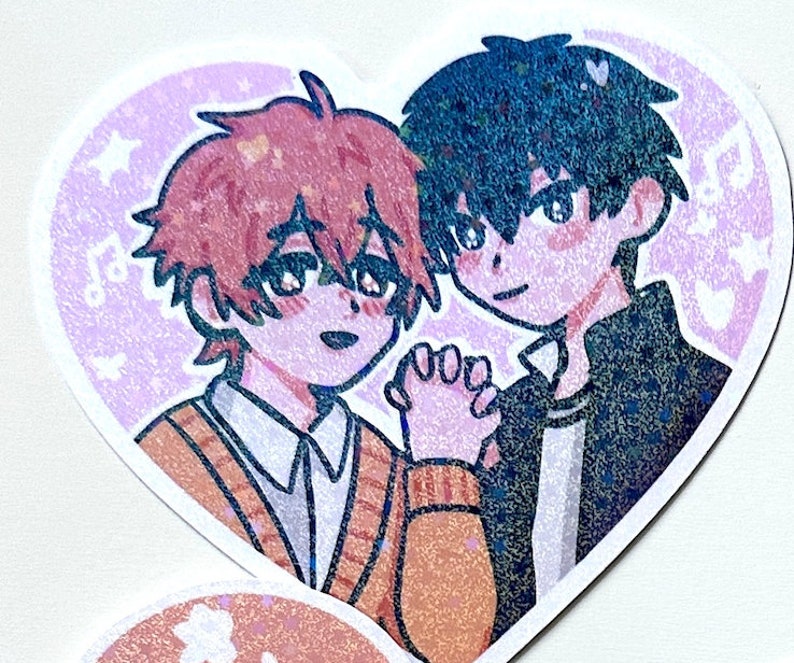 May include: A heart-shaped sticker with two cartoon characters holding hands. The character on the left has brown hair and is wearing a brown sweater. The character on the right has black hair and is wearing a black jacket. The background is a light purple with stars and musical notes.