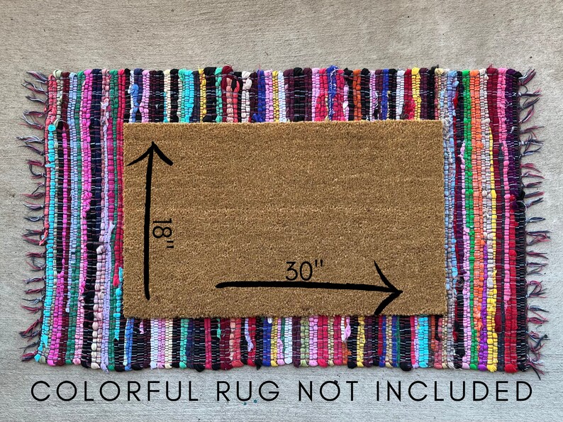May include: A brown coir doormat with a colorful braided rug border. The doormat measures 30 inches by 18 inches. "COLORFUL RUG NOT INCLUDED" is printed below the doormat.