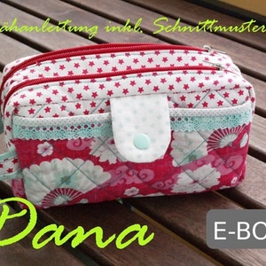 Może przedstawiać: Czerwono-biała kosmetyczka z zamkiem błyskawicznym i uchwytem. Kosmetyczka ma wzór kwiatowy i wzór białych gwiazdek. Na zdjęciu widoczny jest tekst "Nähnanleitung inkl. Schnittmuster" i "Dana E-BOOK".
