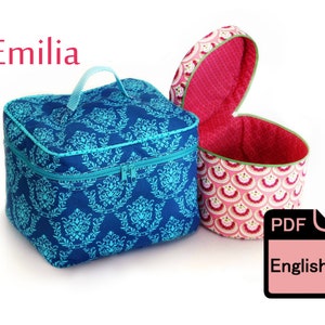 Könnte beinhalten: Zwei Stoffaufbewahrungsboxen, eine blaue mit einem türkisfarbenen Muster und einem Reißverschluss und eine rosa mit einem rot-weißen Muster. Die blaue Box hat einen Griff. Die rosa Box ist offen und hat ein rotes Futter. Der Text "PDF English" befindet sich auf einem rosa Etikett.