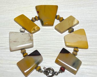 May include: A handcrafted bracelet featuring geometric, polished stone beads in shades of yellow, brown, and cream. The bracelet is connected by small, round beads and a silver-tone clasp. The stones have unique patterns and variations.