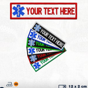 Puede incluir: Un conjunto de seis parches bordados para planchar o coser con un símbolo médico azul y el texto "YOUR TEXT HERE". Los parches están disponibles en negro, blanco, rojo, verde y azul. Los parches miden 12 cm por 2 cm.