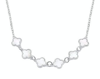 Puede incluir: Un collar de plata con una serie de colgantes blancos en forma de trébol. El collar tiene una cadena delicada y los colgantes están espaciados uniformemente. Los colgantes de trébol tienen un aspecto nacarado, añadiendo un toque de elegancia.