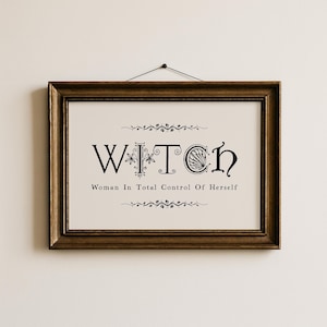 Puede incluir: Un cuadro enmarcado con la palabra "WITCH" en letras negras elegantes, con la frase "Woman In Total Control Of Herself" debajo. La impresi&oacute;n est&aacute; en un marco dorado, colgado en una pared neutra.