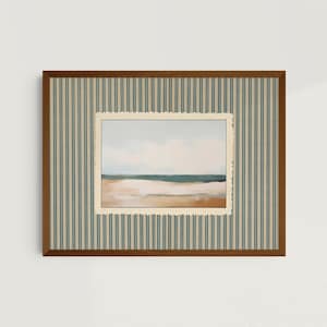 May include: A rectangular wall art piece featuring a landscape painting of a beach with a teal ocean and tan sand, set within a cream-coloured scalloped mat. The mat is surrounded by a beige and teal striped border inside a brown wooden frame.