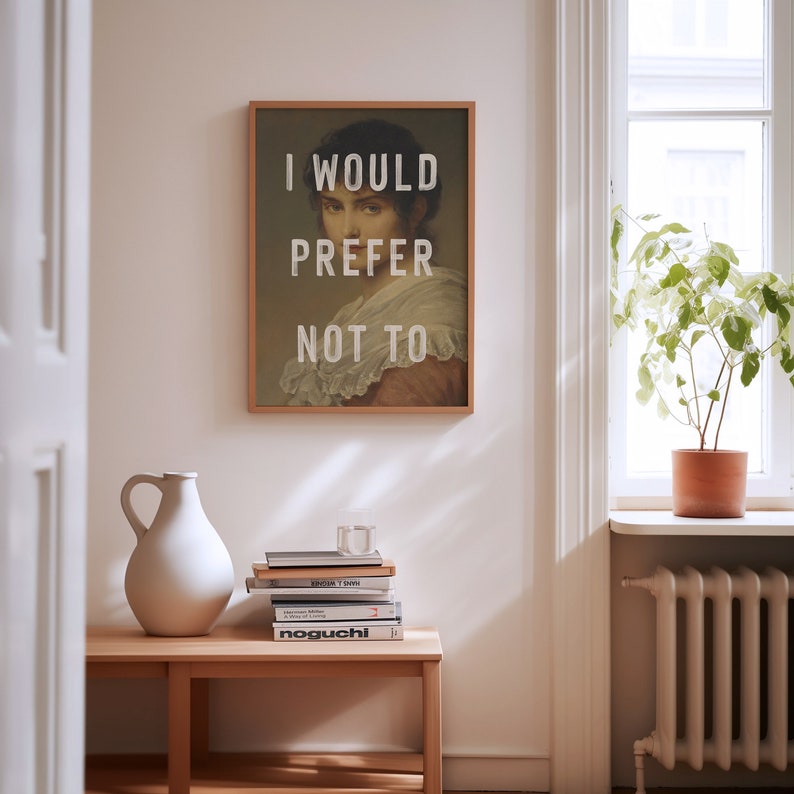 Pu&ograve; includere: Una stampa incorniciata con un ritratto vintage di una donna con il testo "I would prefer not to" in lettere bianche.