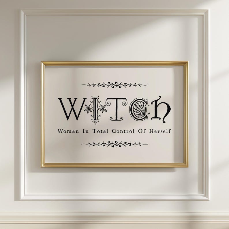 Puede incluir: Una impresi&oacute;n enmarcada con la palabra "WITCH" en letras negras decorativas. Debajo de la palabra est&aacute; la frase "Woman In Total Control Of Herself". La impresi&oacute;n est&aacute; en un marco dorado, montada en una pared blanca.