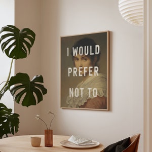 Pu&ograve; includere: Una stampa incorniciata di una donna con il testo "I would prefer not to" sovrapposto all'immagine.