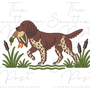 May include: An embroidery design featuring a brown and white spotted hunting dog carrying a mallard duck in its mouth, surrounded by green cattails and grass, with the text The Southern Post and THESOUTHERNPOSTSHOP visible in the background.