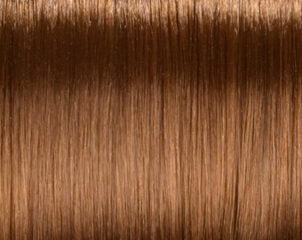 May include: Close-up of a smooth, shiny, light brown hair extension.
