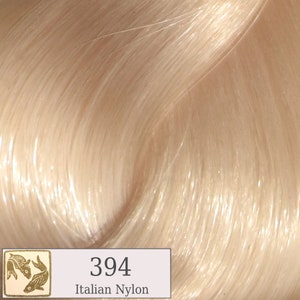 May include: A close-up of a light blonde hair color swatch. The swatch is labeled "394 Italian Nylon".