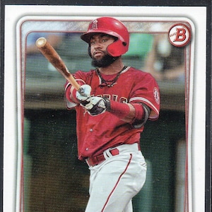 Peut inclure: Une carte de baseball représentant un joueur de baseball portant un maillot rouge avec un pantalon blanc et une casquette de baseball rouge. Le joueur tient une batte en bois et est en position de frappe. La carte a un fond argenté avec le nom du joueur "JO ADELL" et "OF" imprimé en bas. La carte a également un logo des Angels de Los Angeles d'Anaheim.