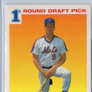 May include: Baseball card featuring Jeromy Burnitz of the New York Mets. The card displays the text "1st Round Draft Pick" and "SCORE 91". Burnitz is shown kneeling, holding a baseball bat, wearing a Mets uniform.