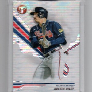 May include: A baseball card featuring a baseball player in a blue and red uniform with the text "ATLANTA BRAVES" and "AUSTIN RILEY" on the card.