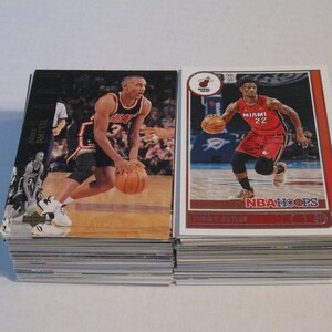May include: Two basketball trading cards featuring NBA players. The card on the left features a player wearing a red and black jersey with the number 3. The card on the right features a player wearing a red jersey with the number 22. Both cards have a red, white, and blue color scheme.