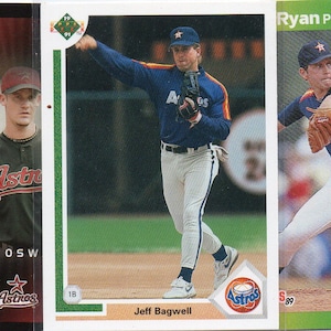 May include: A collection of baseball trading cards featuring players from the Houston Astros. The cards feature photos of the players in their uniforms, along with their names and team logos. The cards are in good condition and would be a great addition to any baseball fan's collection.