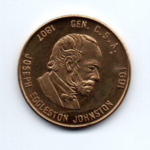 May include: A bronze-colored coin with a portrait of Joseph Eggleston Johnston, a Confederate general, on the obverse. The coin reads "GEN. C.S.A. 1821 JOSEPH EGGLESTON JOHNSTON 1891".