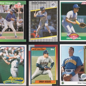 Puede incluir: Una colección de seis tarjetas de béisbol de intercambio con Omar Vizquel, un ex campocorto de la Major League Baseball. Las tarjetas son de diferentes años y presentan diferentes fotos de Vizquel con su uniforme de los Mariners. Las tarjetas están en buen estado y serían una gran adición a cualquier colección de tarjetas de béisbol.