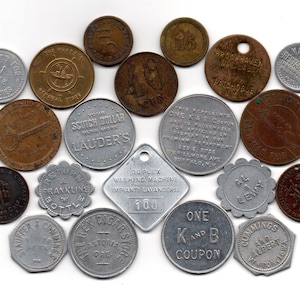 May include: A collection of vintage tokens and coins, including a Lauder's Scotch Dollar, a Duplex Washing Machine token, a Rex Cigars Store token, a K and B coupon, and a Cummings and Albert token. The tokens are made of metal and have various designs and inscriptions.