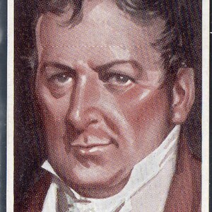 May include: A sepia-toned portrait of a man with a serious expression. He is wearing a white collared shirt with a high neckline and a dark jacket. The image is printed on a card.