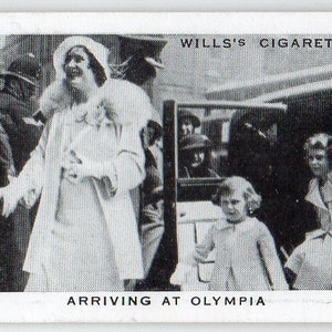 Puede incluir: Una fotografía en blanco y negro de un grupo de personas llegando a Olympia. La foto es de una tarjeta de cigarrillos vintage y presenta el texto "WILLS'S CIGARETTES" y "ARRIVING AT OLYMPIA".