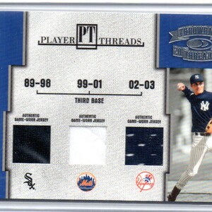 May include: A baseball card featuring Robin Ventura, a former third baseman for the New York Mets. The card shows Ventura in his Mets uniform, with the team's logo and the years 89-98, 99-01, and 02-03. The card also includes the text "Player Threads" and "Throwback 20 Threads 04".