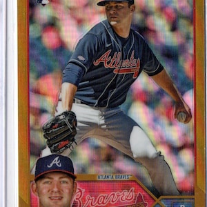 May include: A baseball card featuring Jared Shuster of the Atlanta Braves. The card has a gold border and includes the Topps Chrome logo. Shuster is shown pitching in his Braves uniform.