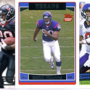 May include: A collection of Houston Texans football trading cards. The cards feature players in action, with team colors of navy, red, and white. Some cards include player names and team logos. The cards are from various brands, including Topps.